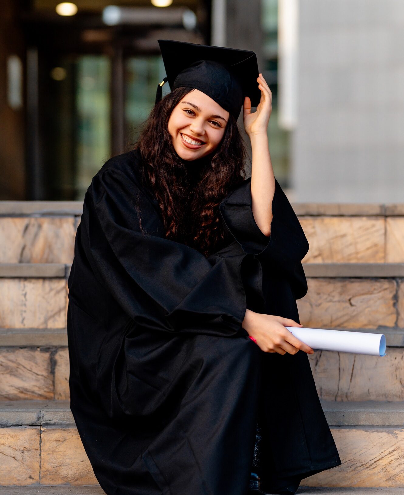 Happy graduate smiling and holding graduation certificate